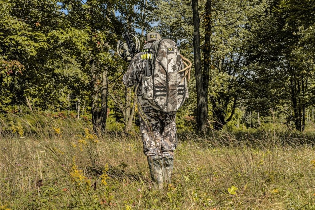 Hunter Walking Through Field With Havoc RS440 Crossbow and Halo Bowpack